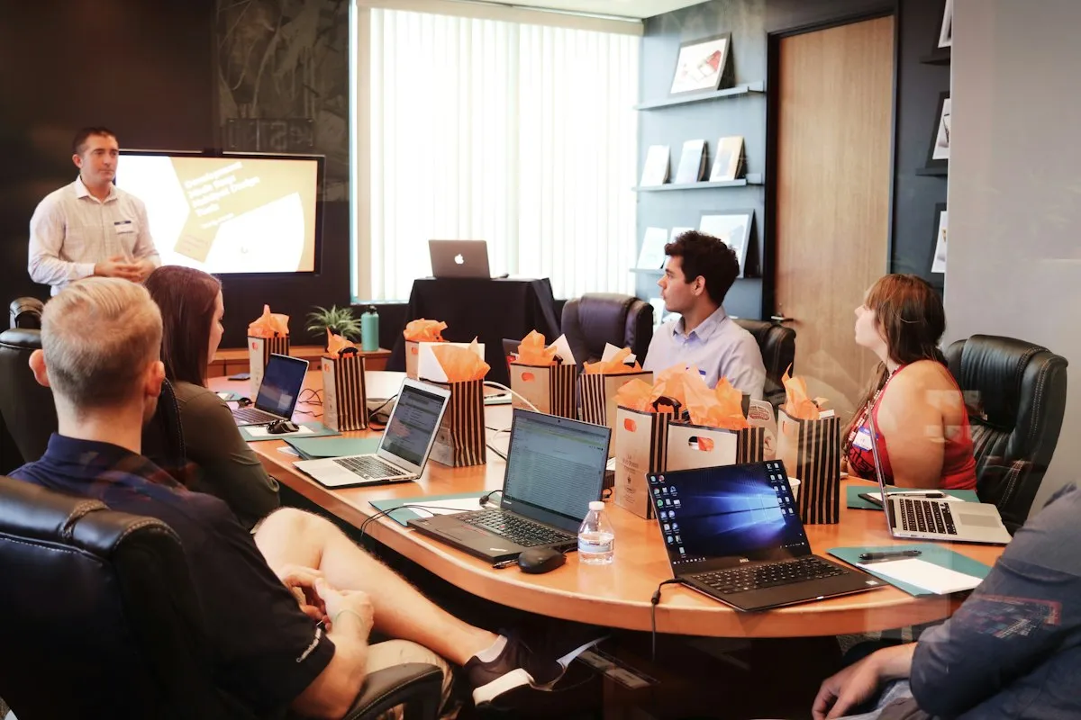 Project team planning delivery around a presentation and laptops