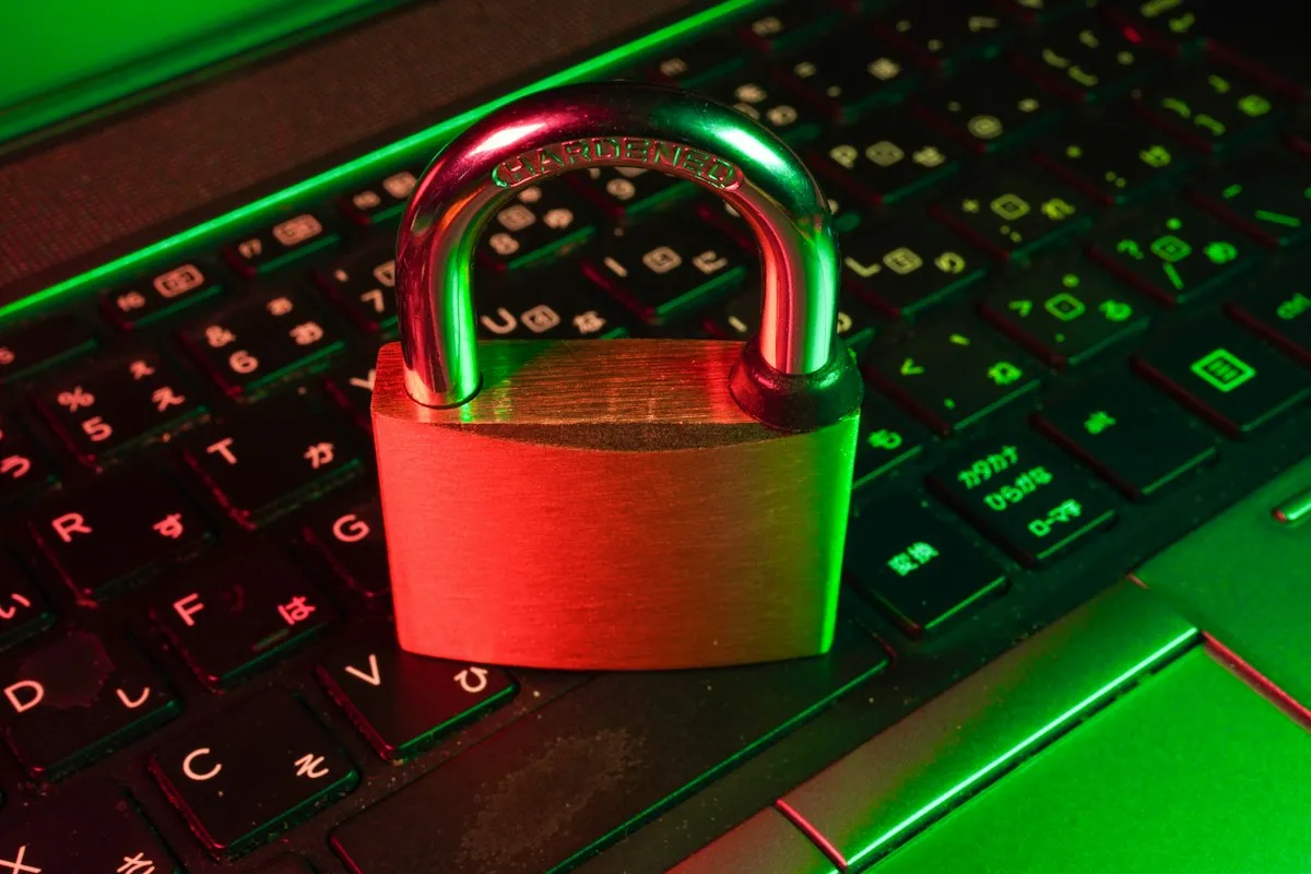 Padlock resting on a computer keyboard under colored security lighting